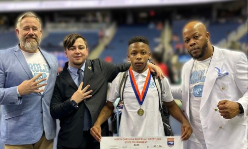  Coach Ben Barry stands with Kolton Manchester, Cam Stinson, Jr., and Cam Stinson, Sr. 